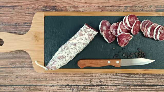 saucisson sec tranch&eacute; sur une planche &agrave; d&eacute;couper	