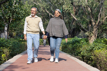 Obraz premium Smiling senior couple enjoying view of nature at public park