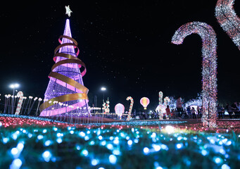 Fake christmas tree and candy cane stick in outdoor garden at night in Chiang Mai of Thailand in...