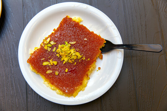 Arabic traditional dessert - knefe or kunafe, konafa on a plate with pistachio - creative delicious middle eastern dish. Arabic Cuisine