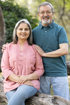 Portrait of Indian senior couple embracing while standing in park.