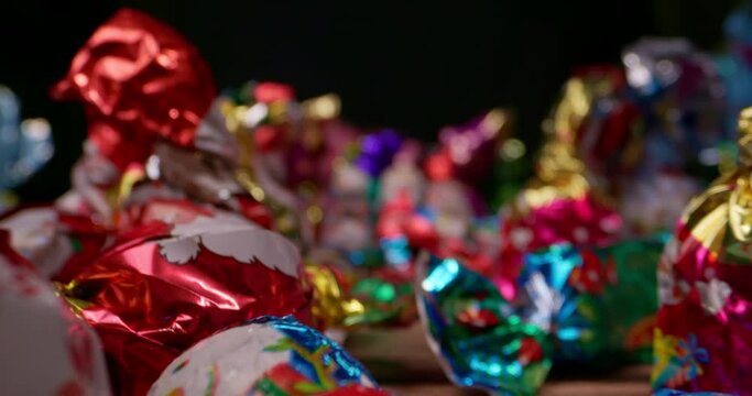 Extremely close up of sweet candies with a Christmas motif on a black background with slow motion in macro mode