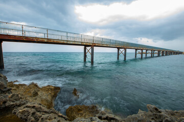 Fototapeta na wymiar Wooden pier by the sea. Pier by the sea made of iron. Wooden pier by the beach. 