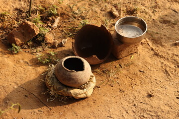 Small clay pots or matka and steel bowl filled with water outside on ground for animals and birds - obrazy, fototapety, plakaty