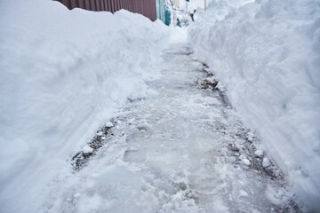 Paths in the city or countryside are covered with ice. The winter problem of snow and ice removal