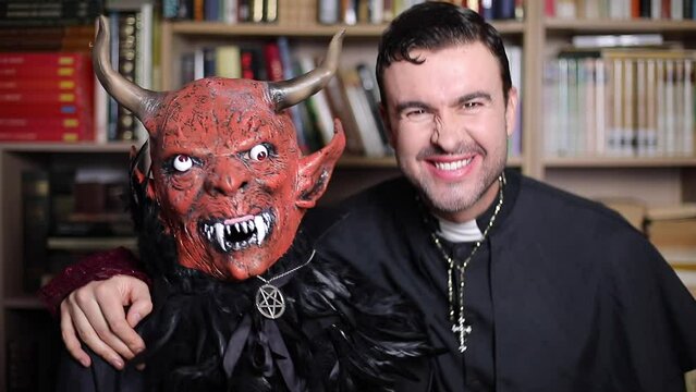 Man and friend dressed as demon and priest for Halloween 