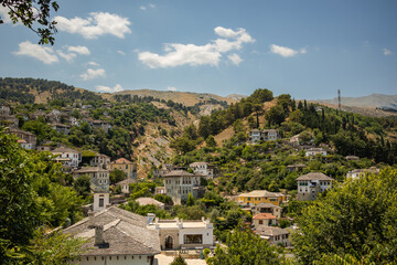 Fototapeta na wymiar Beautiful Hilly Town of Gjirokastër in Southern Albania. Balkan Unesco View of a Village on a Hill with Trees. 