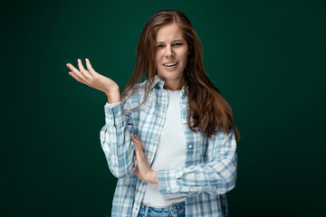 Fototapeta premium Portrait of a well-groomed young lady with natural brown hair on a green background
