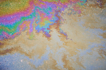 Gasoline pollution, oil, rainbow gasoline leak in the form of a glow on the sidewalk.