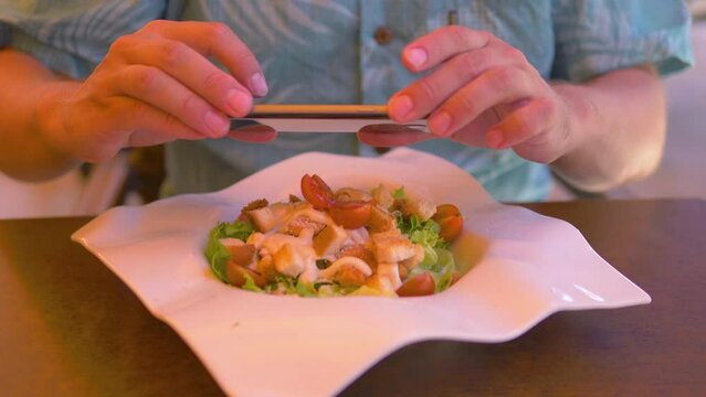 Man taking picture of her lunch at the reastaurant in 4k slow motion 60fps