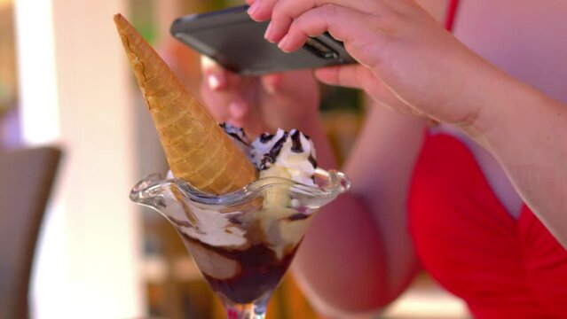 Woman taking picture of tasty ice cream dessert in 4k slow motion 60fps