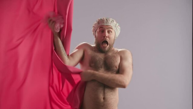 Silhouette of a man washing with a loofah in a shower behind a pink curtain. A man pulls back the curtain and screams in fear and horror, throws a washcloth and hides behind a curtain. Hygiene concept