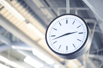 The wall clock tells the time on the station.