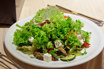 Salad with grilled meat and vegetables and fetta cheese on restaurant table