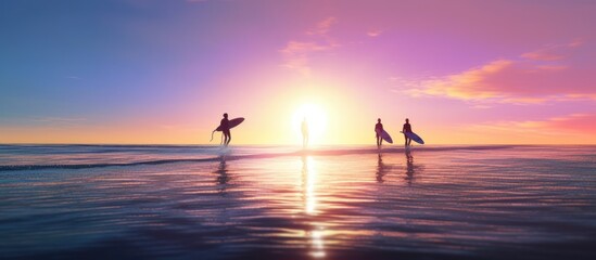 Three friends, surfers, running into the water early in the morning with surfboards in their hands