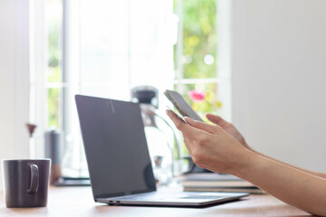 Fototapeta premium Young woman is shopping online through mobile application by paying with her credit card Convenience of paying through shopping online. Concept of online shopping and spending through credit card.