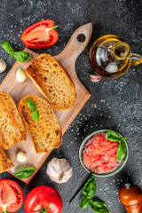 Delicious Italian tomato bruschetta with fresh basil leaves slices on wooden board. place for text, top view