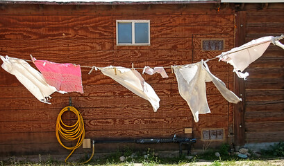 Sheets and clothing dry on an outdoor clothesline on a windy day