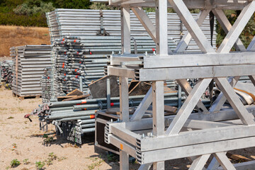 Disassembled aluminum scaffolding, stacked and secured on site.