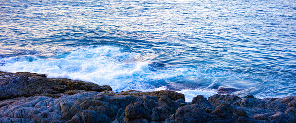 Ocean waves hit the rocky shore.