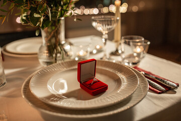 engagement ring in red box on served table - obrazy, fototapety, plakaty