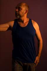 Portrait of bearded, bald man looking to the side in blue shirt.