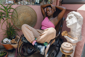 young short hair haitian woman resting sitting on wooden rocking chair at home