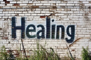 Fototapeta na wymiar The word healing is boldly spray-painted in black on a white brick wall