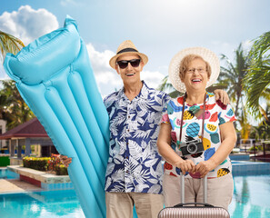 Happy senior couple with a swimming mattress
