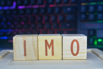 Photo of words with wooden block objects arranged into the word "IMO" in English