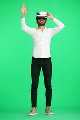Fototapeta na wymiar full-length man on a green background wearing 3D augmented reality glasses