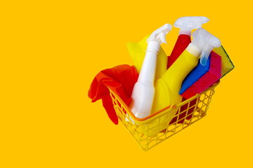 Household chemicals rubber gloves washcloths rags for cleaning in shopping basket Detergent bottles...