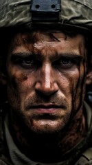 Close up portrait of man, soldier in mud with wet head, pained and exhausted looking at camera.
