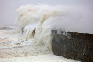Huge Waves crashing a stone pier during a storm at Hartlepool Headland, County Durham, England, UK.