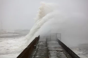 Rolgordijnen Huge Waves crashing a stone pier during a storm at Hartlepool Headland, County Durham, England, UK. © Colin Ward