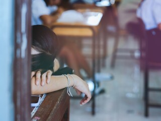 A female student who is tired from taking a difficult exam is discouraged and falls asleep during...