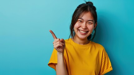 Lucky winner. Cheerful charismatic asian cute urban girl stand yellow t-shirt smiling friendly pointing finger camera choosing, picking person, inviting you team, stand happy blue background - obrazy, fototapety, plakaty