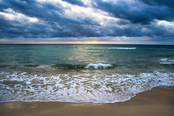 Sun is rising on a cloudy day over the ocean