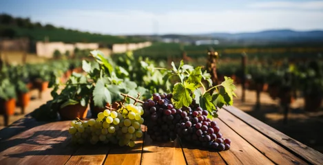 Fototapeten Wine grapes on wooden table and blurred autumn vineyards background.  Natural template with beauty bokeh and warm sunlight. Concept banner for products display. © Bobboz