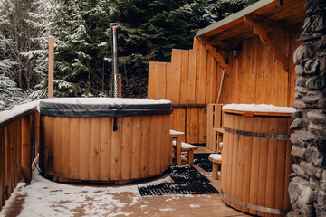 Open-air bath interior near forest, winter, snow view. Wooden hot tub outside