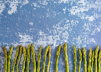 Asparagus arranged next to each other in a row on a marble background, asparagus background