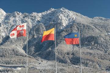Waving Liechtenstein national flag in an alpine winter panorama in Vaduz