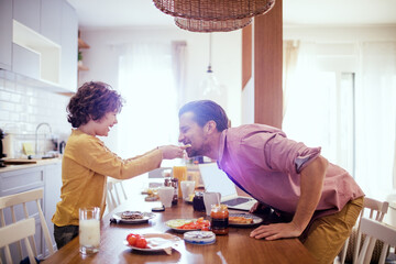 Father and son enjoying breakfast at home