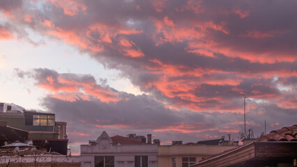 View of the red sky and clouds over houses in the city of Istanbul. Daybreak or sunset time.
