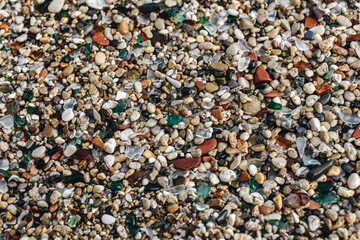 Mix of pebbles and broken glass on a municipal beach in Syracuse, Sicily.