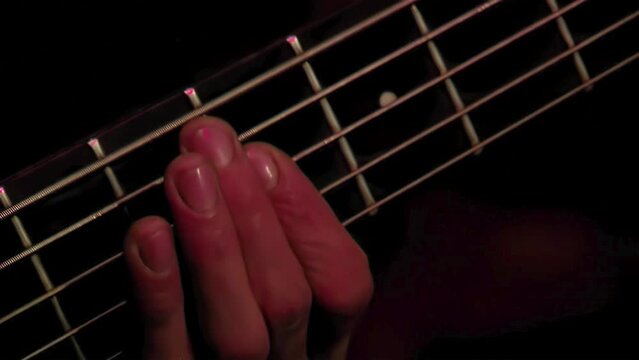 Man Playing a Bass Guitar on Stage. Close Up.