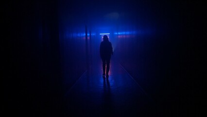 Portrait of female in the dark hallway with neon light. Woman with flashlight walking down the corridor with door and staircase.