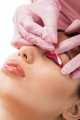 Make-up artist makes the procedure of lamination and dyeing of eyelashes to a beautiful woman in a...