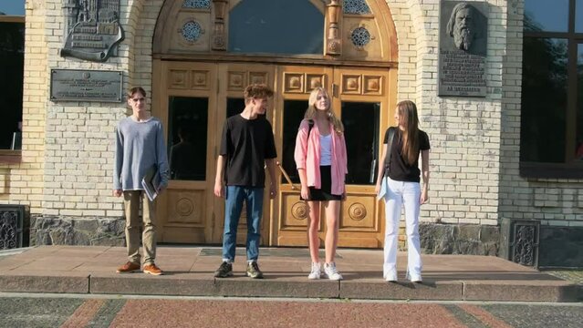 Students look at each other against front door of university. Gaining high-quality knowledge in higher education institution