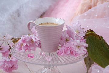 cup with drink coffee cappuccino, hot chocolate with milk, pink sakura flowers, caffeine improves functioning of human brain, stimulates nervous system, health benefits and harms, copy space, banner